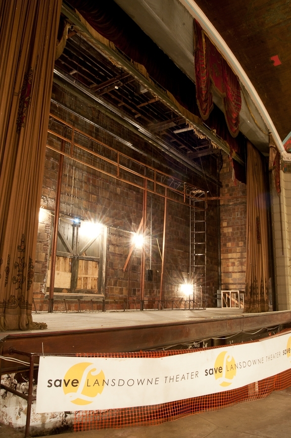 The stage of the Lansdowne Theater with a Save Lansdowne Theater banner.